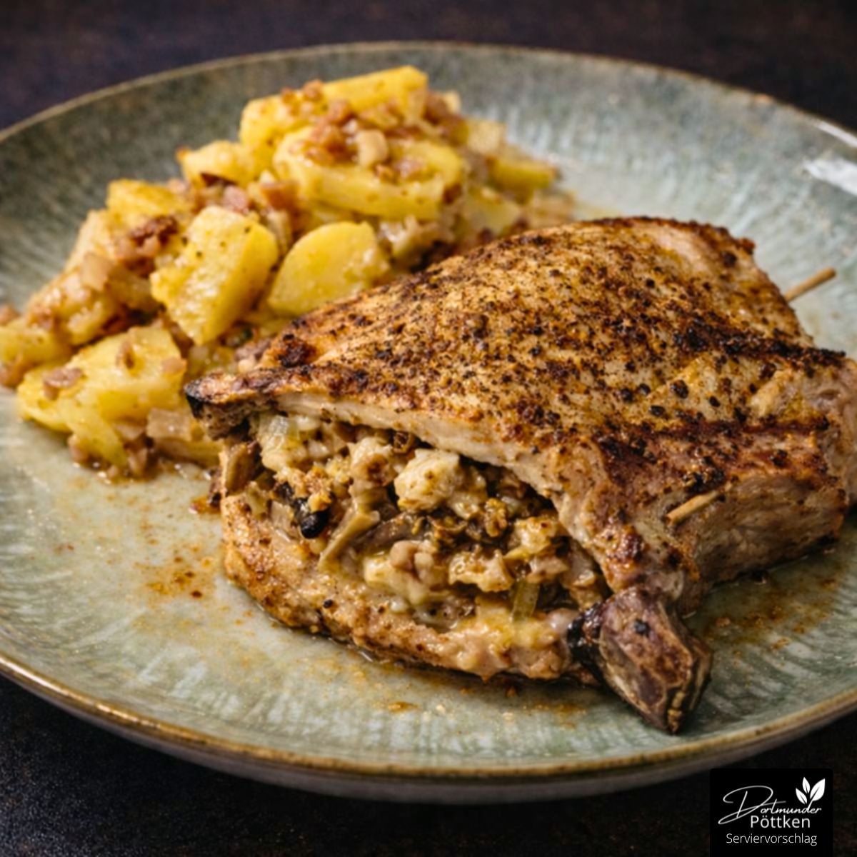 Gefülltes Schweinekotelett mit knuspriger Kruste und Bratkartoffeln auf einem Keramikteller angerichtet.