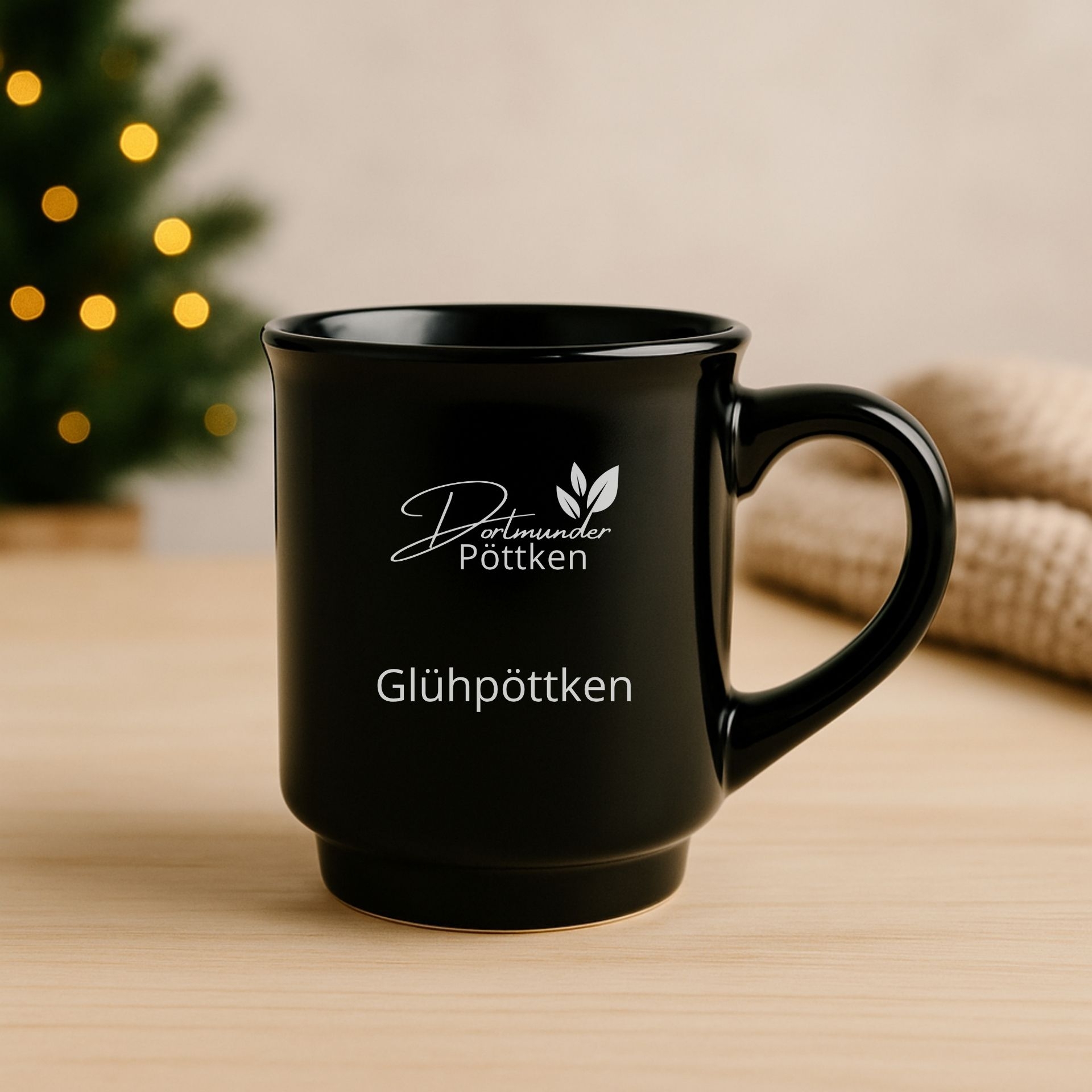 Schwarzer Gluehweinbecher Gluehpoettken mit Dortmunder Poettken Logo auf Holztisch vor Weihnachtsbaum